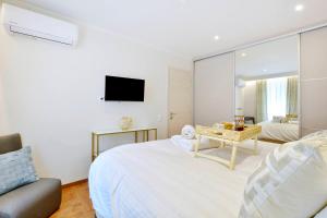 a white bedroom with a bed and a mirror at Mar Luxury Suite in Corfu Town