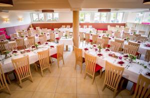una sala da pranzo con tavoli e sedie bianchi di Gasthof Zur Post a Ossiach