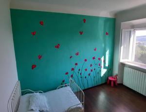 un dormitorio con una pared verde con mariposas rojas. en La casa di Montegiardino en San Marino