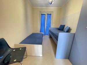 a small bedroom with two beds and a chair at Costa Paestum Apartment in Paestum