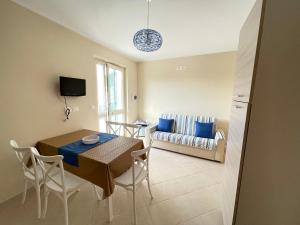 a living room with a table and chairs and a couch at Costa Paestum Apartment in Paestum