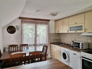 a kitchen with a table and chairs and a microwave at Apartments Šćepanović in Kolašin