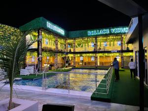 un edificio con una piscina delante de él por la noche en Rollace Hotel en Ikeja