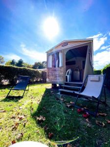 una piccola roulotte con due sedie e una tenda di Camping Le Royan a Royan