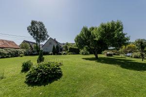 a green yard with trees and a house at Lubja Holiday House in Pärnu