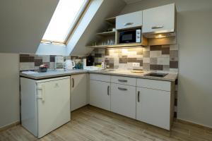 d'une cuisine avec des placards blancs et une lucarne. dans l'établissement Star Apartman, à Eger