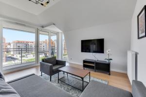 a living room with a couch and a tv at GRANO FLATS Gdańsk - RiverFront Apartment in Gdańsk