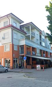un grande edificio su una strada con un'auto di fronte di Prémium Apartman a Hajdúszoboszló Altre 2 foto
