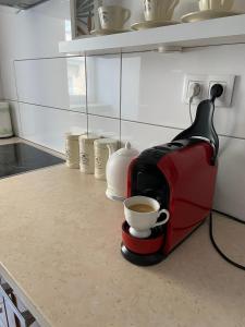 Apartament na Starówce VI في بيشتنا: آلة صنع القهوة على منضدة مع كوب من القهوة
