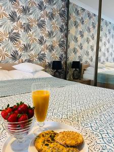 stół z talerzem jedzenia i szklanką soku pomarańczowego w obiekcie Apartament na Starówce VI w Pszczynie