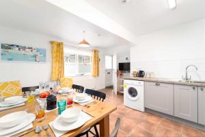 uma cozinha e sala de jantar com uma mesa de madeira e cadeiras em 4 Porthmeor Court em St. Ives