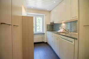 a kitchen with white cabinets and a sink and a window at Utoring 412 by Arosa Holiday in Arosa