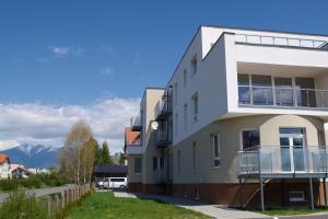 a white apartment building with mountains in the background at Little Home in Liptovský Mikuláš