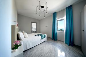 a bedroom with a bed with blue curtains and a chandelier at Palazzo Novecento in Margherita di Savoia +48 photos