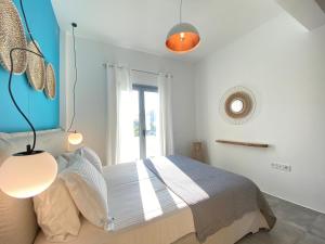 a bedroom with a bed with a blue wall at Marton Perissa in Perissa