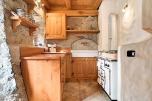 cocina con armarios de madera y estufa blanca en Chalet Bio Wild, en Bocenago