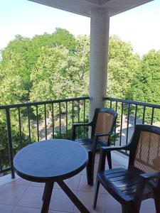 2 sillas y mesa en un balcón con mesa en Prémium Apartman en Hajdúszoboszló