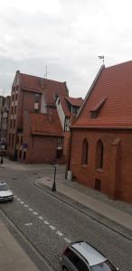 a street with buildings and a car parked on the road at Apartamenty Irena Stare Miasto Św. Ducha in Elblag