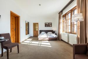 a bedroom with two beds and a table and a chair at Willa Hyrny in Bukowina Tatrzańska