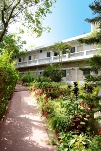 a walkway in front of a building with plants at Rising Sun Retreat in Mount Ābu