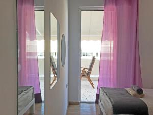 a bedroom with pink curtains and a bed and a mirror at Athens by foot: Perfect flat with terrace in Athens