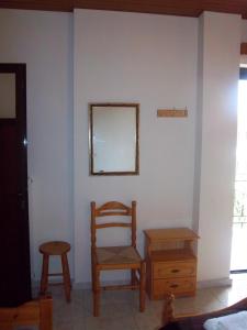 a room with a chair and a table and a mirror at Poulithra Beach in Poulithra