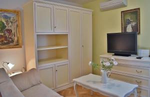 een woonkamer met een bank en een tv bij Apartment Palace in Rab