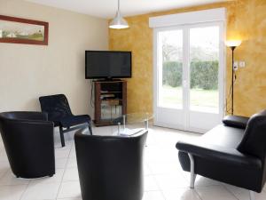 ラ・テュルバルにあるHoliday Home La Fariente - LTB320 by Interhomeのリビングルーム(椅子、薄型テレビ付)