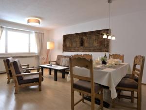 a dining room and living room with a table and chairs at Apartment Chesa Ova Cotschna 606 by Interhome in St. Moritz