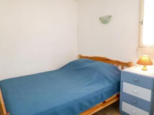 a small bedroom with a blue bed and a blue dresser at Holiday Home Les Jardins du Barcarès-1 by Interhome in Le Barcarès