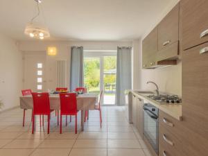 コーリコにあるApartment Legnoncino - CCO419 by Interhomeのキッチン(ダイニングテーブル、赤い椅子付)