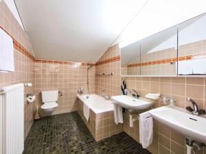 a bathroom with two sinks and a toilet at Apartment Ringstrasse - Utoring-49 by Interhome in Leukerbad