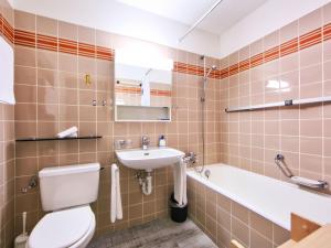 a bathroom with a toilet and a sink and a tub at Apartment Ringstrasse - Utoring-22 by Interhome in Leukerbad