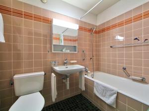 a bathroom with a toilet and a sink and a tub at Apartment Ringstrasse - Utoring-34 by Interhome in Leukerbad
