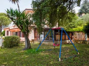 une balançoire installée dans une cour à côté d'un arbre dans l'établissement Villa Sunny home by Interhome, à Sperlonga