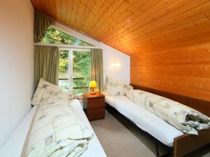 two beds in a room with a window at Apartment Ringstrasse - Utoring-51 by Interhome in Leukerbad +18 photos