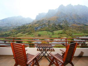 two chairs and a table on a balcony with mountains at Apartment Ringstrasse - Utoring-51 by Interhome in Leukerbad
