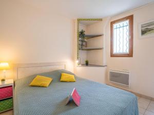 a bedroom with a bed with two yellow pillows at Apartment Coulaoun by Interhome in Biarritz