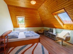 バラトンアカラッチャにあるHoliday Home Amaryllis by Interhomeのベッドルーム1室(ベッド1台付)、屋根裏部屋(テレビ付)