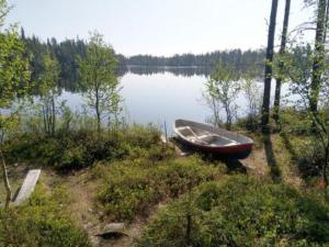 a boat sitting on the side of a lake at Holiday Home Ullanlinna by Interhome in Käylä