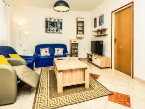 salon z niebieską kanapą i stolikiem kawowym w obiekcie Apartment Dragica-1 by Interhome w mieście Podorjak