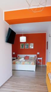 a bedroom with an orange wall and a bed at Talìa Residence in San Giorgio