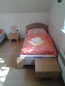 a bedroom with a bed with a book on it at Penzion Richnava in Štiavnické Bane