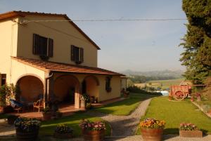 a house with a yard with flowers in pots at Agriturismo Il Cantastorie in Montepulciano