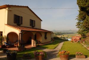 una casa con un patio con flores en ollas en Agriturismo Il Cantastorie, en Montepulciano