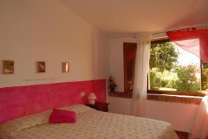 Schlafzimmer mit einem Bett und einem Fenster in der Unterkunft Agriturismo Il Cantastorie in Montepulciano