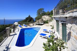 a swimming pool on the side of a house at Villa Bepo i Ivo in Makarska