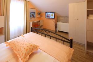 ein Schlafzimmer mit einem Bett und einem TV in einem Zimmer in der Unterkunft Villa Bepo i Ivo in Makarska