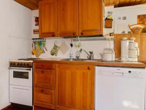 une cuisine avec des placards en bois et un appareil blanc dans l'établissement Holiday Home Piennarpää by Interhome, à Kalmari