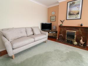 a living room with a couch and a fireplace at 8 Bowjey Terrace in Penzance